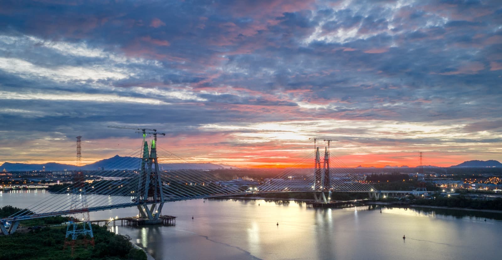 Cable-stayed bridge under construction at sunset